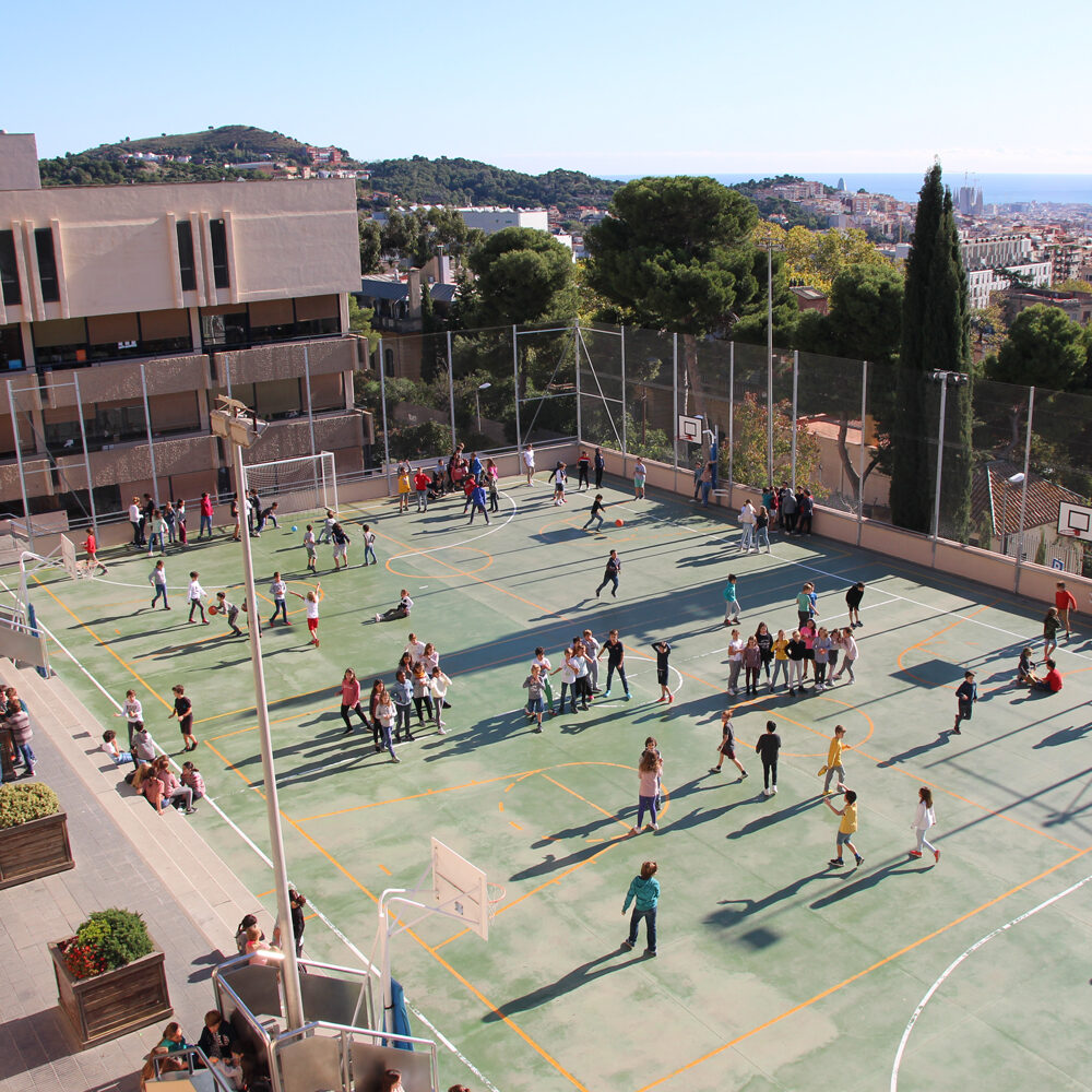 Vista aèria del pati de l'escola amb les vistes de Barcelona de fons